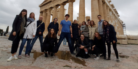 Eine Gruppe Studierender vor einem antiken Gebäude in Griechenland.