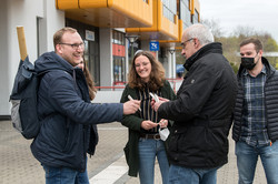 TU-Rektor Manfred Bayer verteilt Kugelschreiber an Studierende.