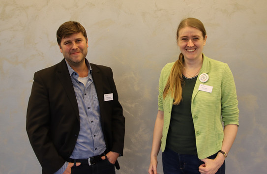 Zu sehen sind Dr. Tobias Heindel (links) und Dr. Doris Reiter (rechts) vor einer grauen Wand. 