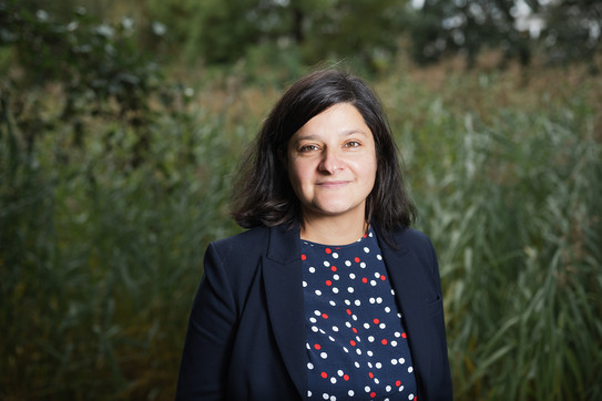 Das Foto zeigt die Professorin Mona Motakef vor einer Wiese.