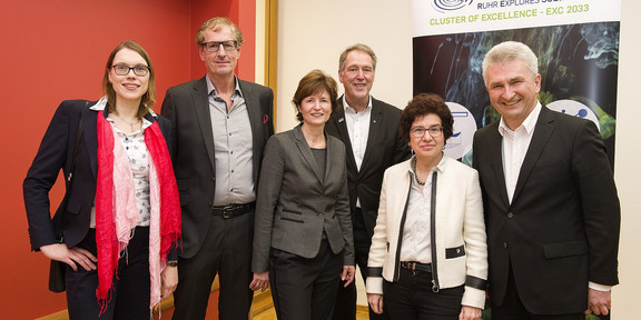 RESOLV Sechs Personen auf einem Gruppenbild. Sie lächeln in die Kamera. Im Hintergrund ein Aufsteller mit der Überschrift RESOLV