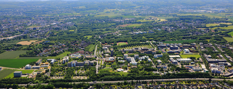 Foto: Eine Luftaufnahme vom Campus der TU Dortmund und der umliegenden Straßen im Sommer.