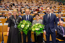 Eine Gruppe von Personen mit Blumensträußen