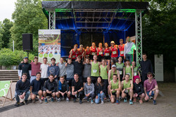 Siegerehrung der Uni-Wertung, Läufer*innen stehen in Teams vor einer Bühne