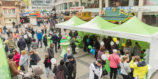 Viele Menschen stehen an und um den TU-Stand in der Innenstadt.