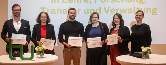 Gruppenfoto: Die Preisträger*innen der Internationalisierungspreise posieren für ein Gruppenfoto vor der Leinwand bei der feierlichen Verleihung.