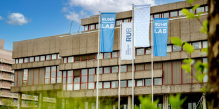 Foto: Auf dem Campus der Ruhr-Universität Bochum stehen Flaggen der Ruhr-Universität Bochum, TU Dortmund und des Ruhr Innovation Lab.