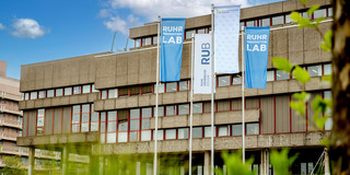 Photo: Flags of Ruhr University Bochum, TU Dortmund, and the Ruhr Innovation Lab fly on the campus of Ruhr University Bochum.