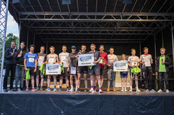 many people stand on the stage and hold up their prizes, vouchers for non-alcoholic beer