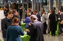 A full hall with people at high tables.