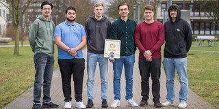 Gruppenbild "Ingenieure ohne Grenzen Challenge" Zu sehen sind fünf Studenten, die in einer Reihe nebeneinander stehen und ihre Erfindung, das "Light Lab Board" in der Hand halten.