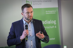 Foto: Eine Person spricht mit Mikrofon.