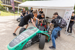 Eine Gruppe junger Männer schiebt an einem Go-Cart