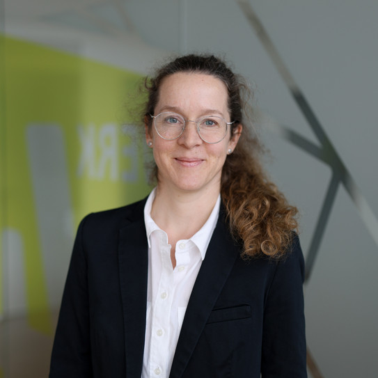 Prof. Almut Balleer Portraitfoto von Prof. Almut Balleer vor grauen und gelb verschwommenen Hintergrund