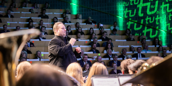 Der Dirigent des Sinfonischen Blasorchesters, Constantin Hesselmann, dirigiert das Orchester während eines Konzertes.