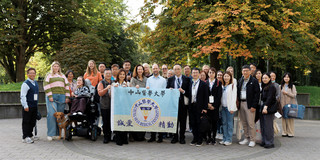 Foto: Es ist eine große Gruppe von Meneschen aus Deutschland und Taiwan zu sehen, die ein Schild hochhalten. Auf dem Schild steht Chung Shan Medical University.
