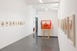 Ausstellung Goldenes Wunder In einer Ausstellungsecke steht ein Kunstwerk, an den Wänden hängen Bilder.
