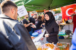 Zwei Studierende unterhalten sich an einem Stand mit türkischem Essen