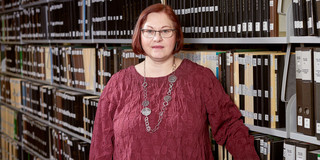 Marra Portrait von Stephanie Marra vor einem Regal mit Akten.