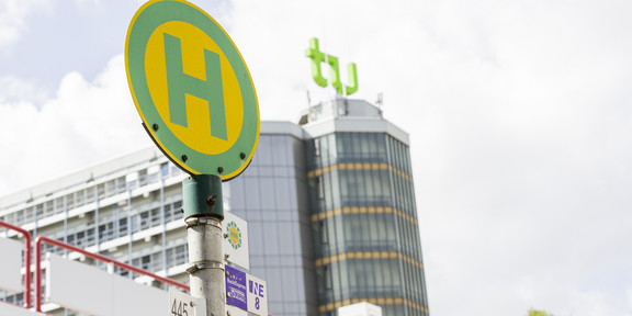 A green and yellow stop sign in front of the Mathetower.