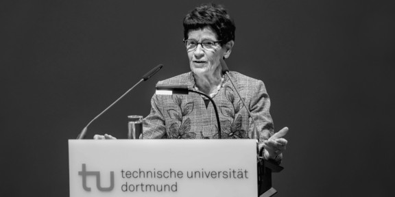 Foto: Eine Person spricht an einem Rednerpult der Technischen Universität Dortmund.