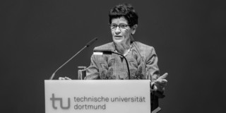 Foto: Eine Person spricht an einem Rednerpult der Technischen Universität Dortmund.