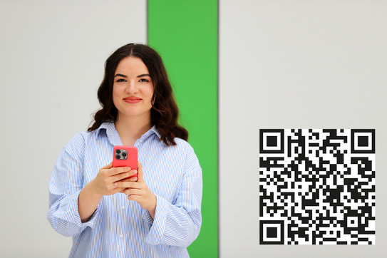 Studierende mit einem Mobiltelefon und WhatsApp QR Code