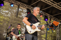 Ein Mann mit Gitarre singt auf einer Bühne