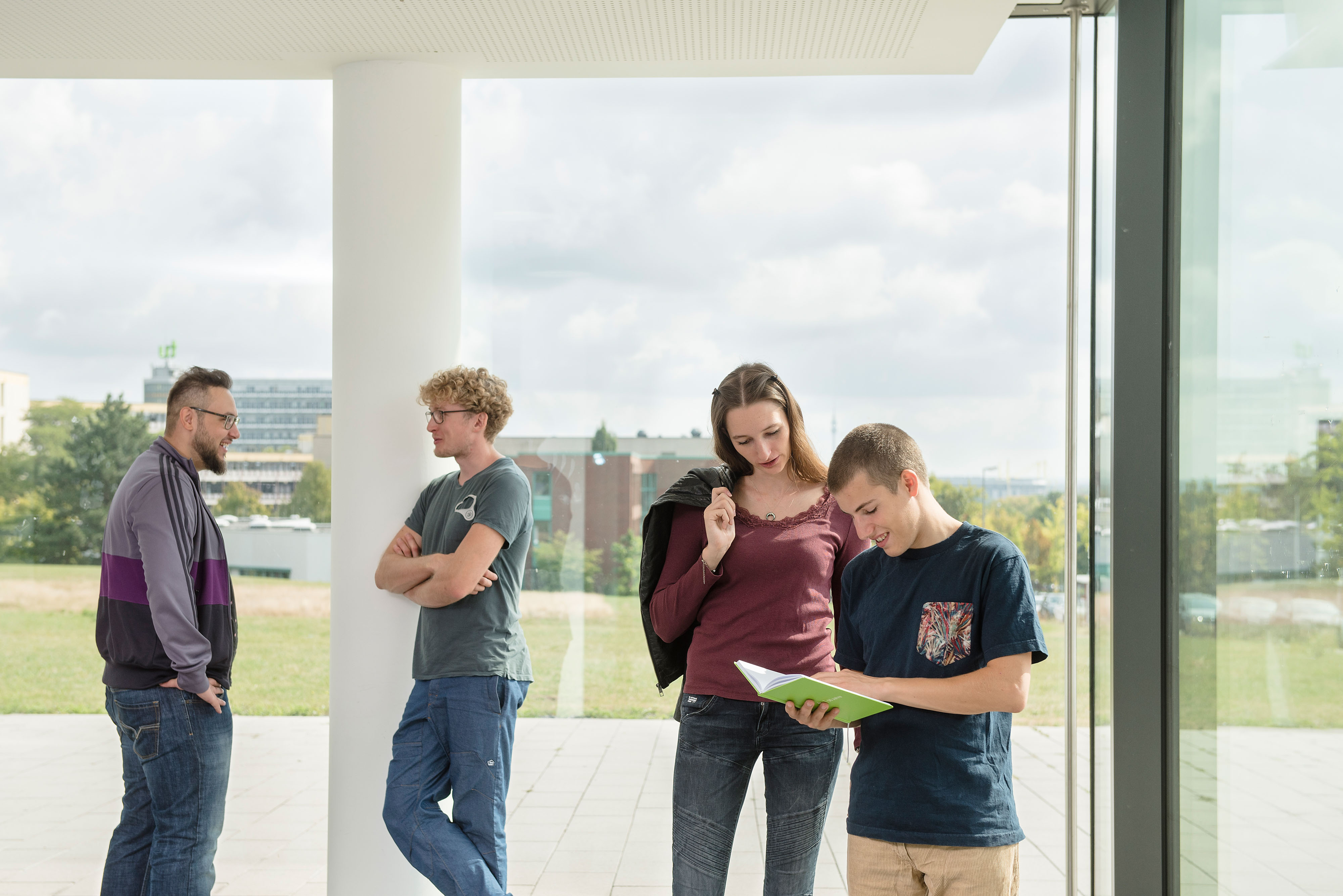 Studierende, Gespräch, Fenster Studierende im Gespräch vor einem großen Fenster.