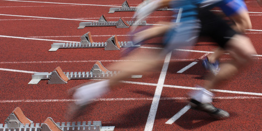 Several Sprinter are starting side by side from starting blocks.