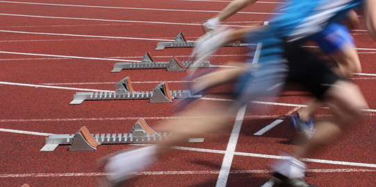 Startschuss Mehrere Sprinter nebeneinander starten aus Startblöcken.