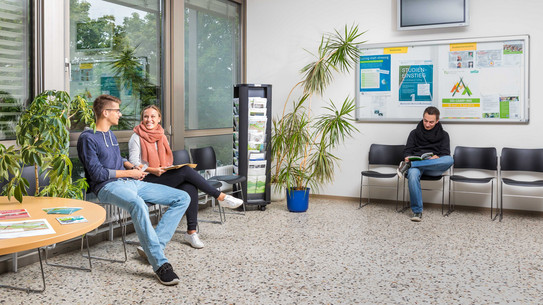 Studierende sitzen im Wartebereich der Studienberatung