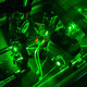 Eine Detailaufnahme eines Lasers im Labor in dunkel grünen Farben.