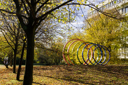 Spektralringe aus Stahl umgeben von Bäumen im Herbst. 