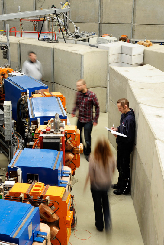 Indoor shot of three persons doing research at the electron storage ring DELTA