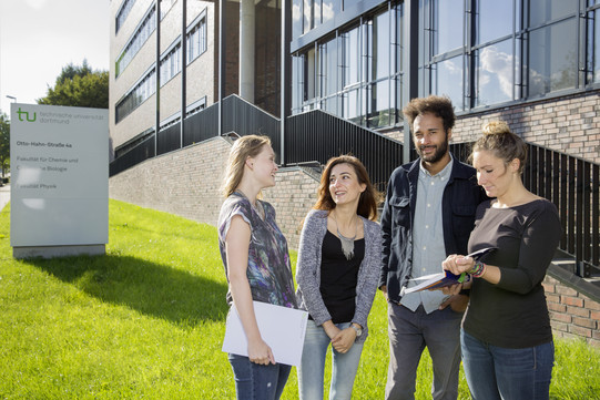 Vier Studierende stehen vor dem neu errichteten Physikgebäude.
