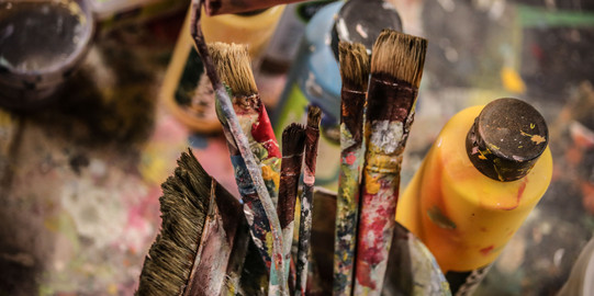 Bunte Pinsel und Farbtube Pinsel voller Farbe in einem Becher und Farbtuben