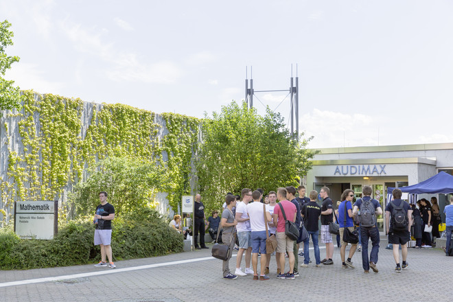 Audimax Studierende stehen vor dem Haupteingang des Audimax.
