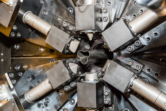 Maschinenbau_07 Ein Metallrohr wird in einer Maschine geformt.