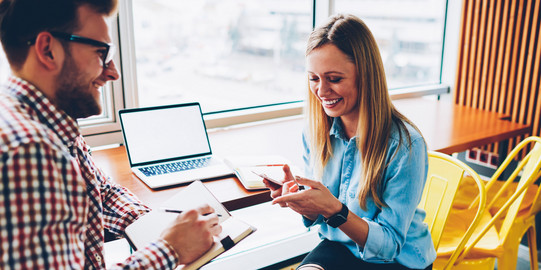 meeting situation 01 A man with a notebook and a pen and a woman sitting at a desk, facing each other and smiling