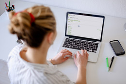 Februar Foto einer Frau, die auf einen Laptop blickt.