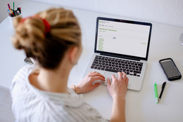 Februar Foto einer Frau, die auf einen Laptop blickt.