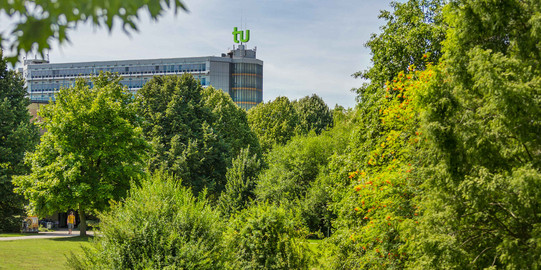 TU Dortmund in summer_01 The mathematics building with green trees in the foreground.