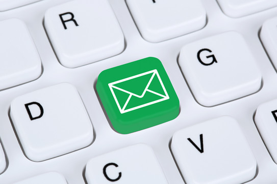 email Detail of a white computer keyboard including a green button with a white envelope symbol