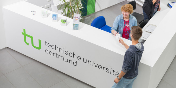 Studierendenberatung Ein Student gibt seine Wartenummer bei der Studienberatung ab.