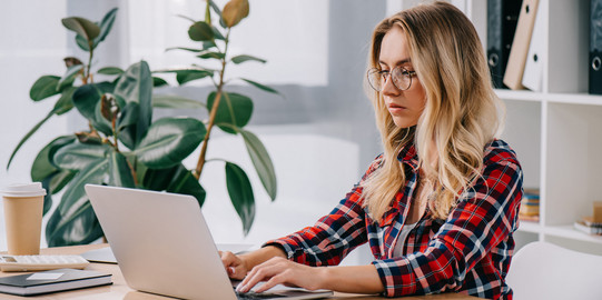 Frau sitzt am Laptop Frau sitzt vor einem Laptop und tippt