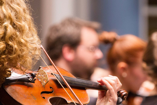 Detail view of a violinist in an orchestra