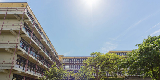 A big grey building with trees in front of it