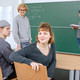Studierende Tutorium Zwei Studierende im Seminarraum im Vordergrund sitzen. Ein Studierender steht mit dem Dozierenden an der Tafel.