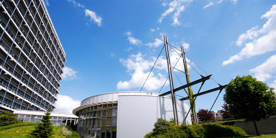 Audimax und Mathematikgebäude Panoramaaufnahme des Audimax und des Mathematik-Gebäudes mit blauem Himmel.
